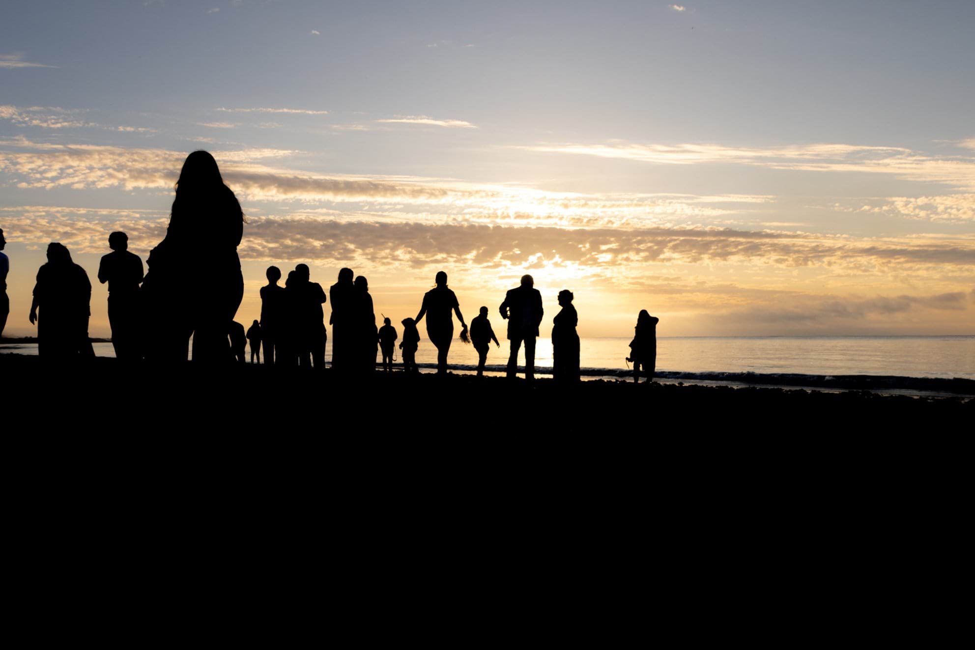 Silhouettes of people attending dawn ceremony at the Convincing Ground.
